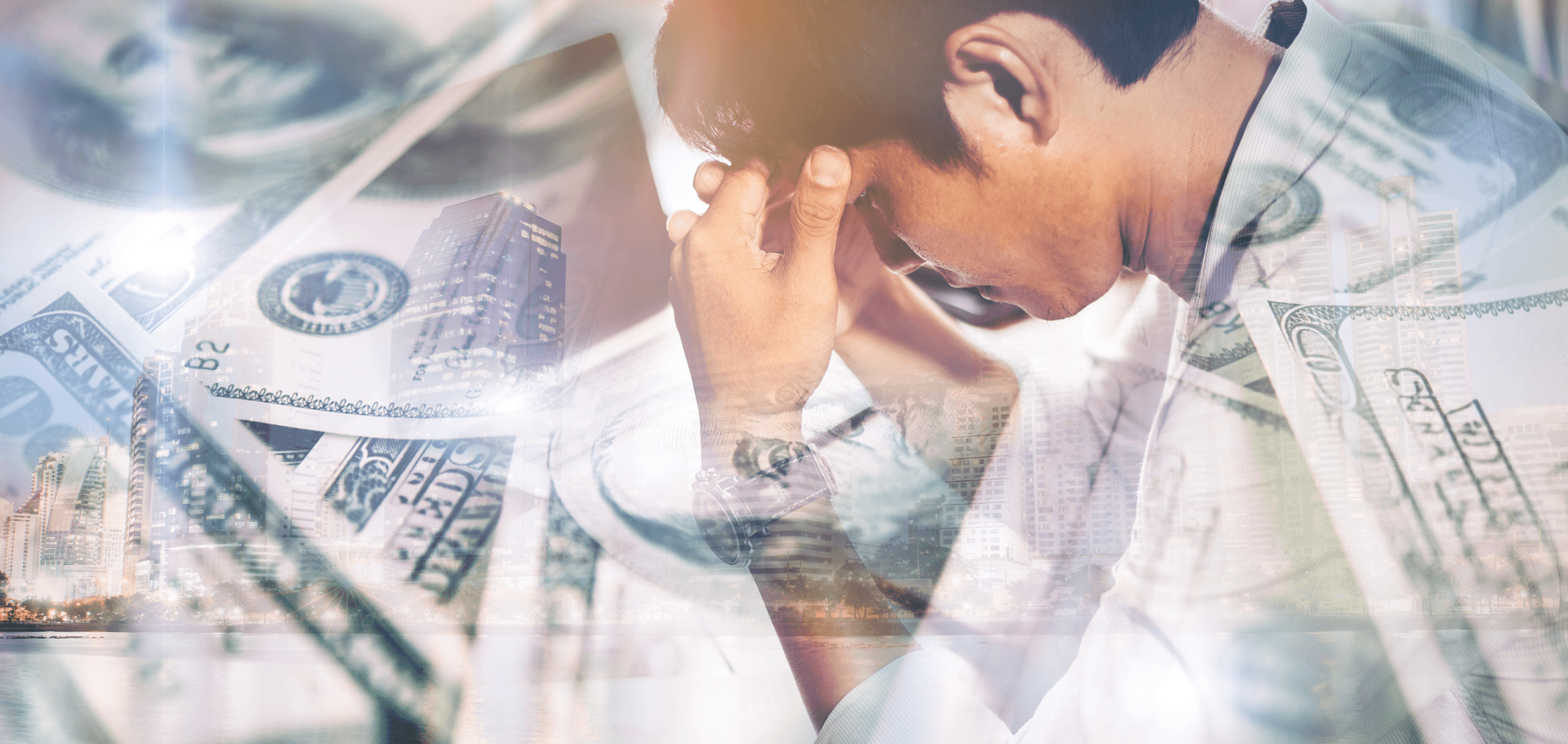 A person sits with their head in their hands, overlaid with images of dollar bills, conveying financial stress or worry about money.