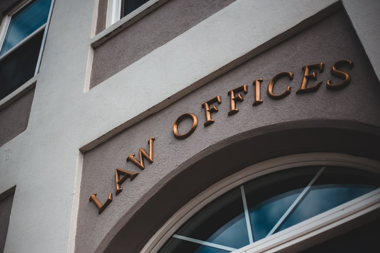 Close-up of the exterior of a building with the words "LAW OFFICES" in gold letters above an arched window.